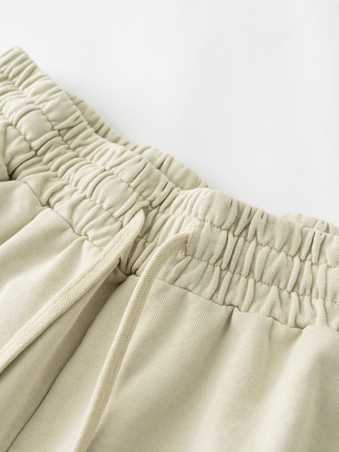 Khaki sports shorts waistband close-up - reinforced elastic and heavy cotton construction