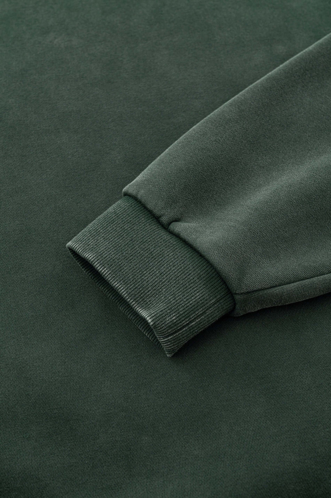 Close-up of the sleeve cuff of the Distressed Panel Crewneck | Men's Fleece Lined Sweatshirt 360g in dark green.