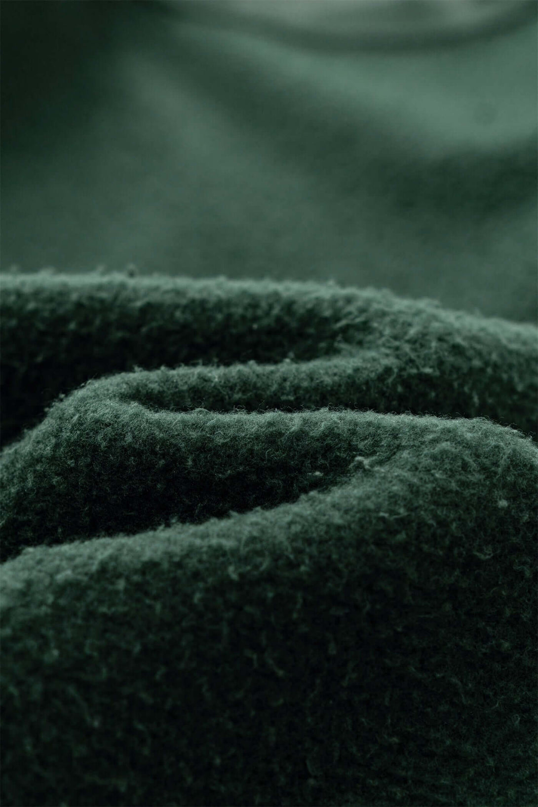 Close-up of soft green fabric showcasing the texture of the Distressed Panel Crewneck men's fleece lined sweatshirt.