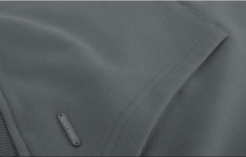 Close-up of the decorative metal rivet on the front pocket of the cotton hoodie.