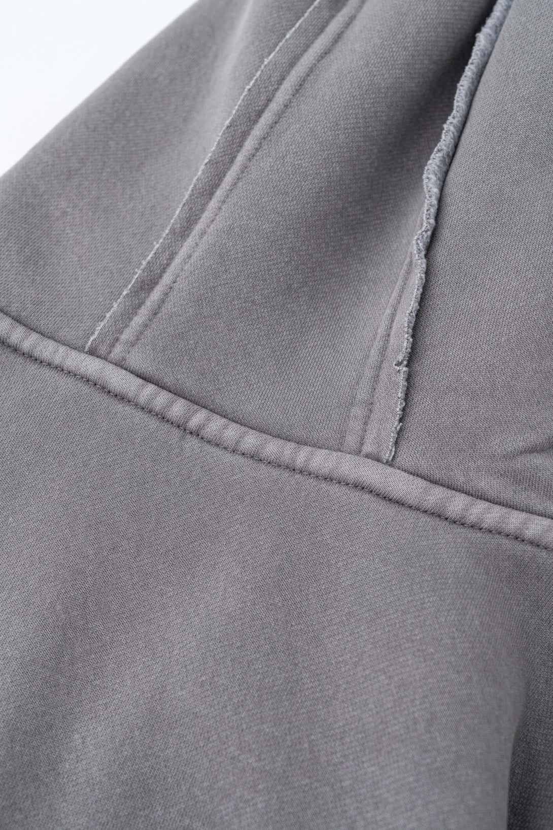 Close-up of the fabric texture on the Double Zip Washed Hoodie, showcasing the grey brushed fleece and stitching details.