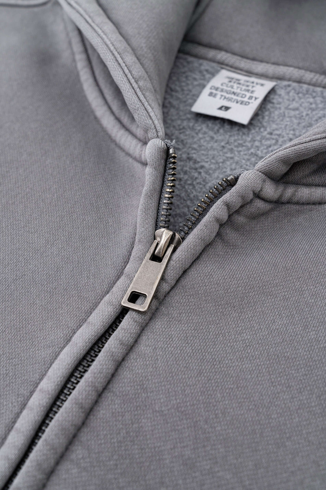 Close-up of the zipper on the Double Zip Washed Hoodie, showcasing premium fabric and design details