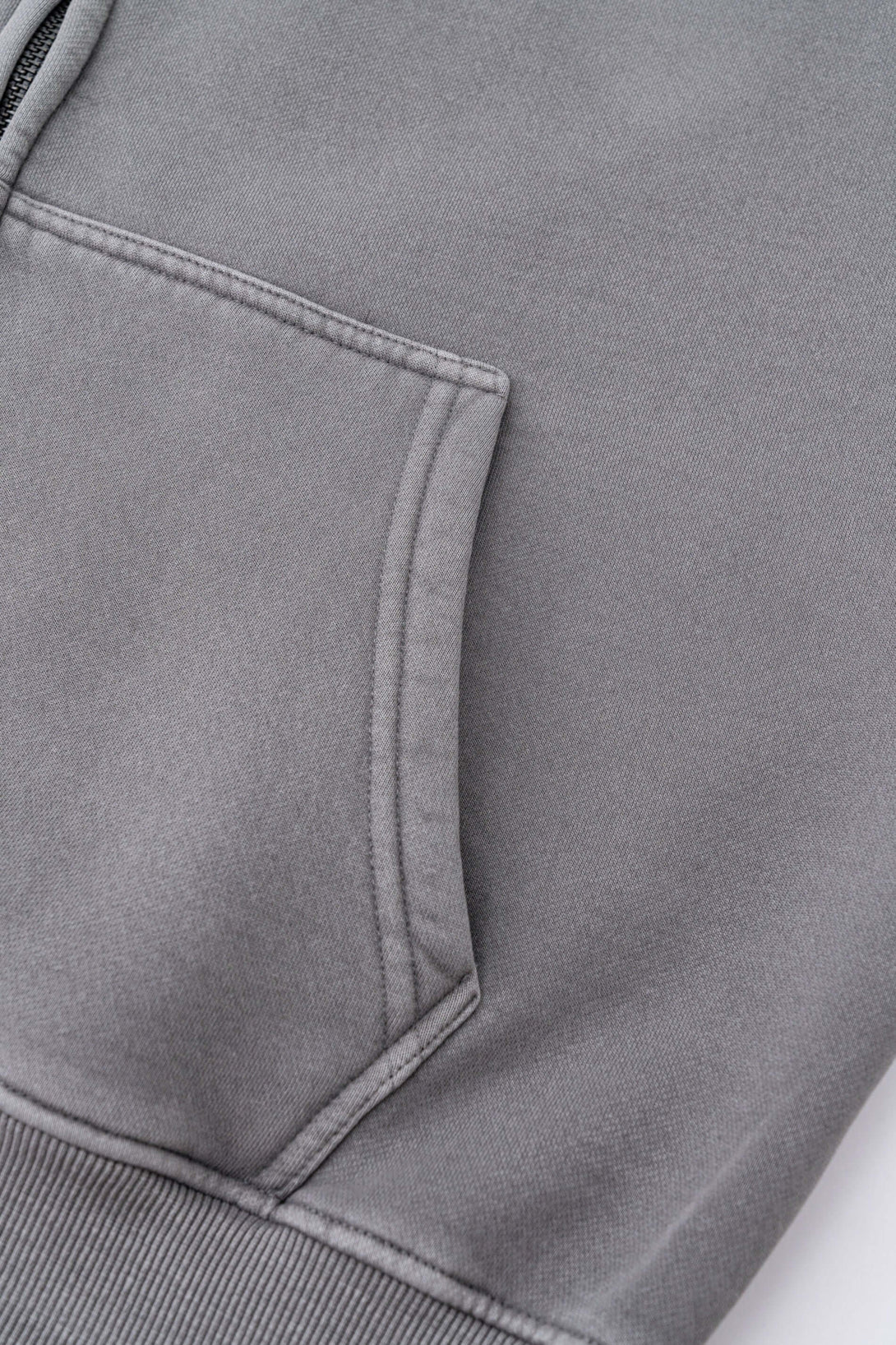 Close-up of the pocket detail of the Double Zip Washed Hoodie showcasing its premium brushed fleece material.