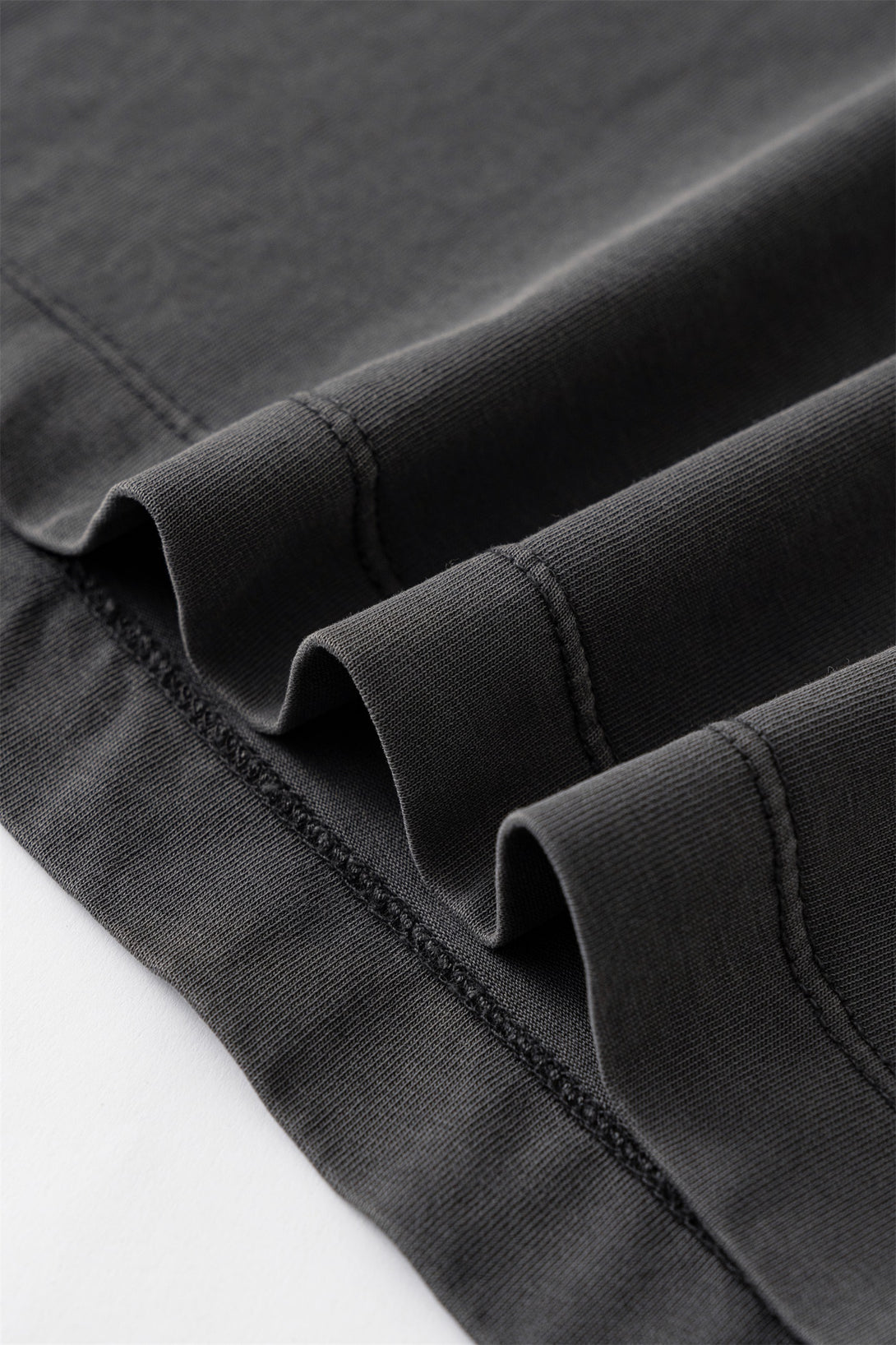 Distressed hem detailing with fabric texture on Women's Dark Gray cotton streetwear tee.