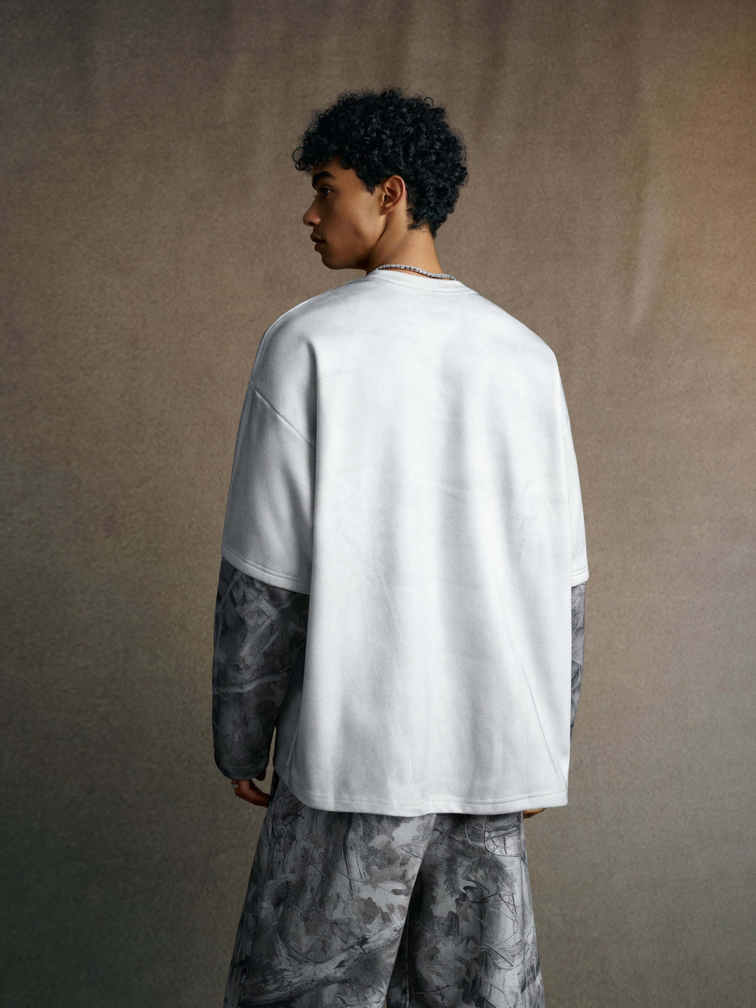 Men's 340g Gray Spray-Dye Camo Crew Neck - back view showcasing fabric and camo design in a stylish urban setting.