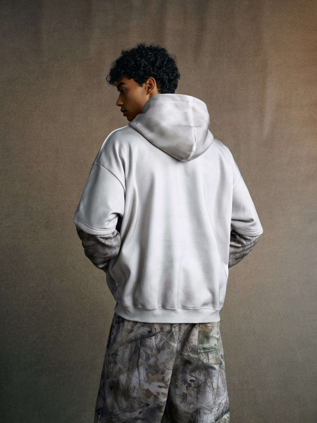 Men's 340g Grey Camo Weighted Hoodie featuring spray-dye fabric technology and layered sleeves.