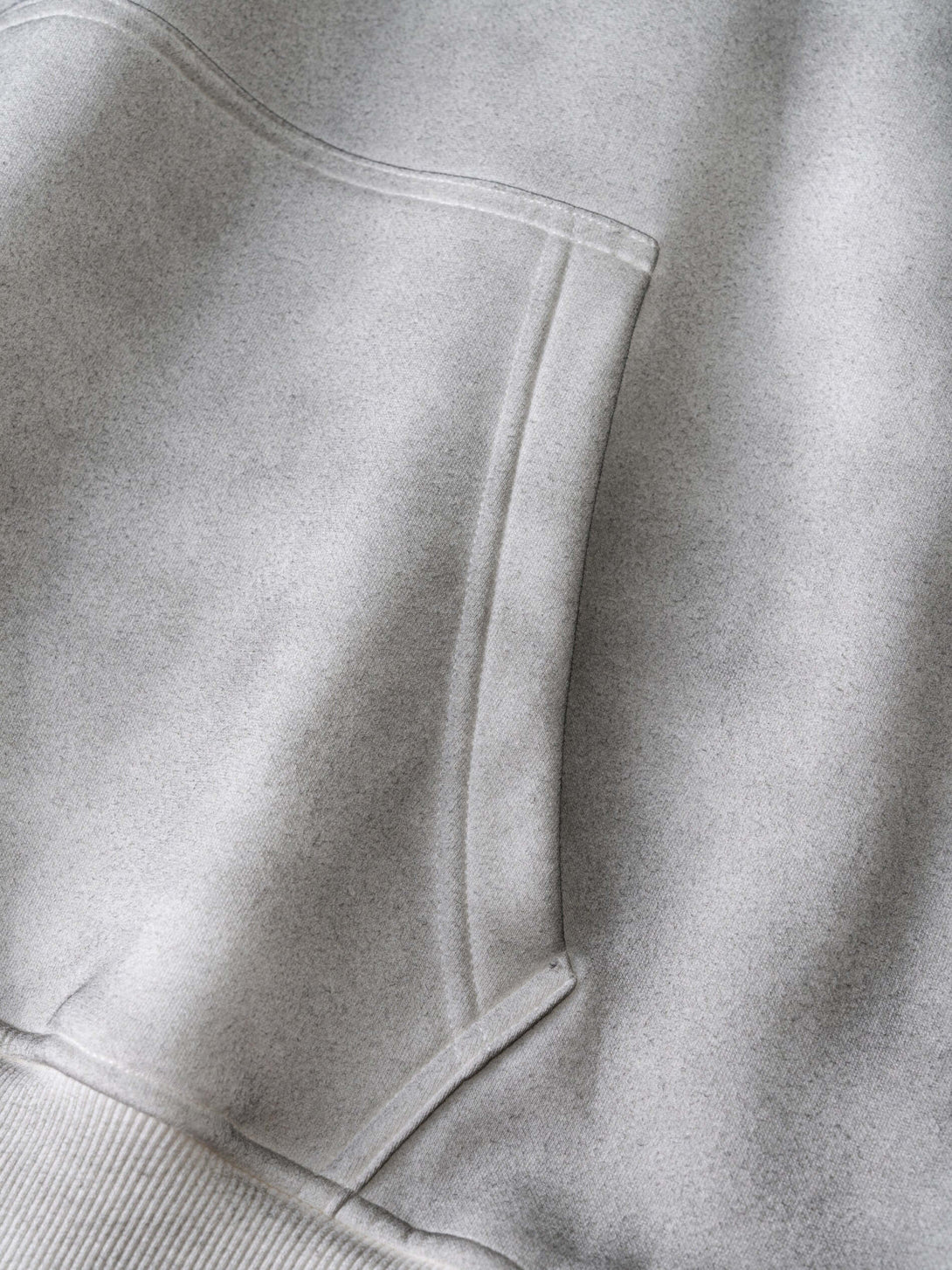 Close-up of pocket detail on Men's 340g Grey Camo Weighted Hoodie, showcasing soft fabric and urban design.