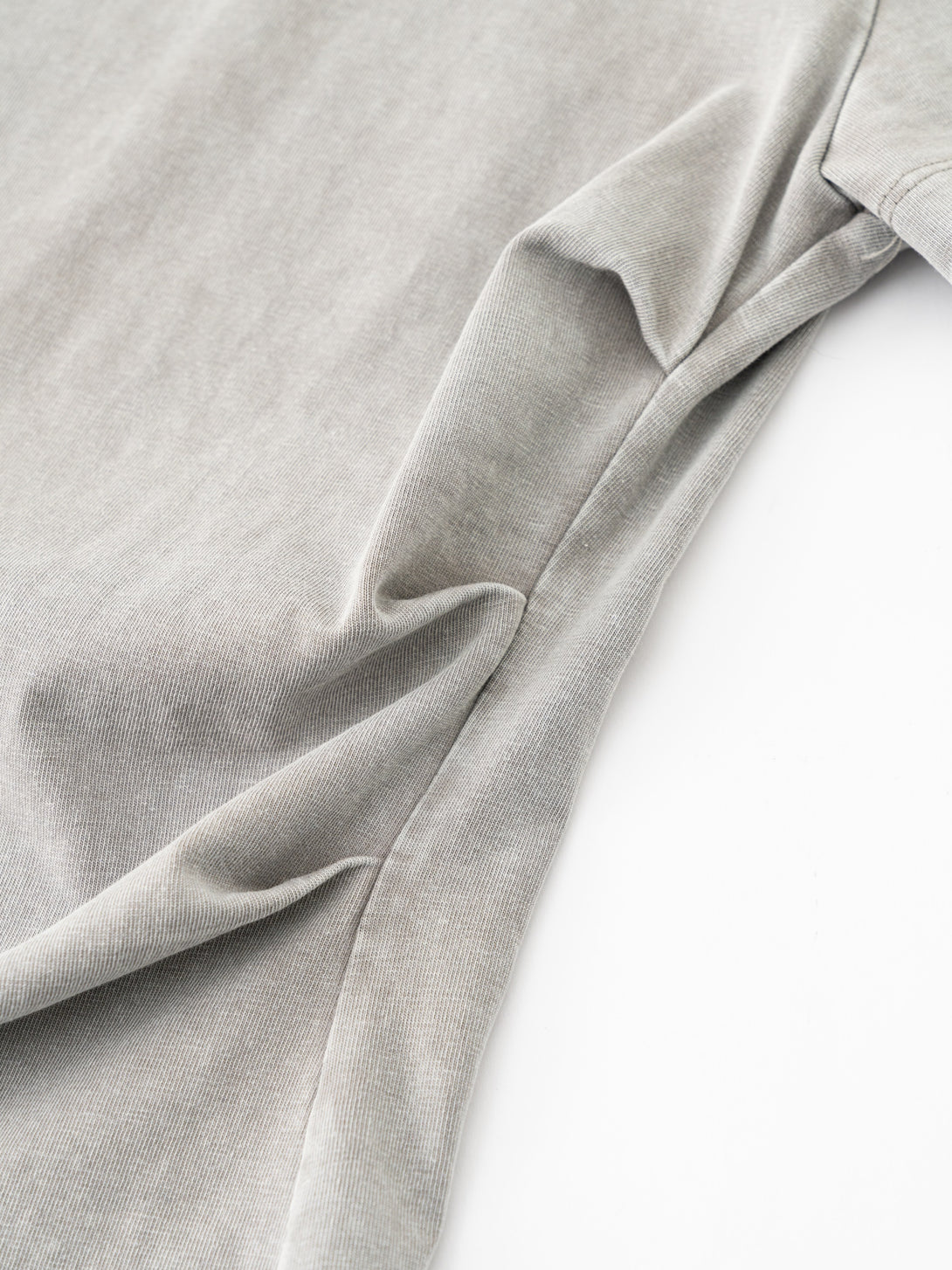 Detail of waist gather design for slim fit on heavy wash women's t-shirt