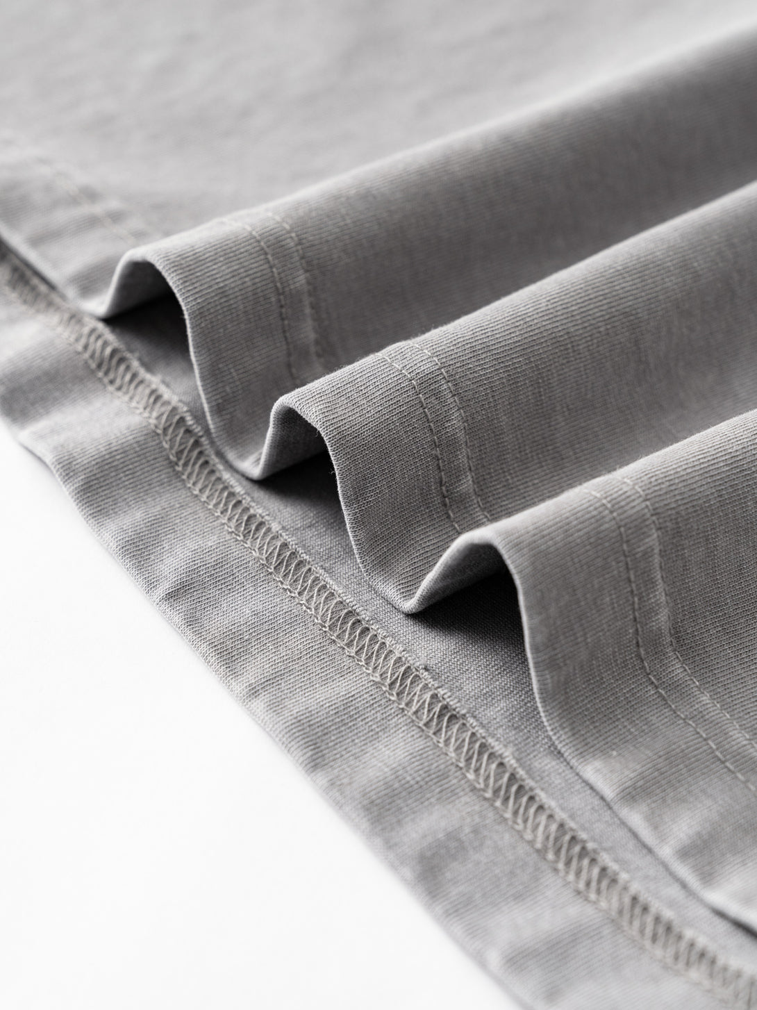 Distressed hem detailing on Light Gray oversized streetwear t-shirt.