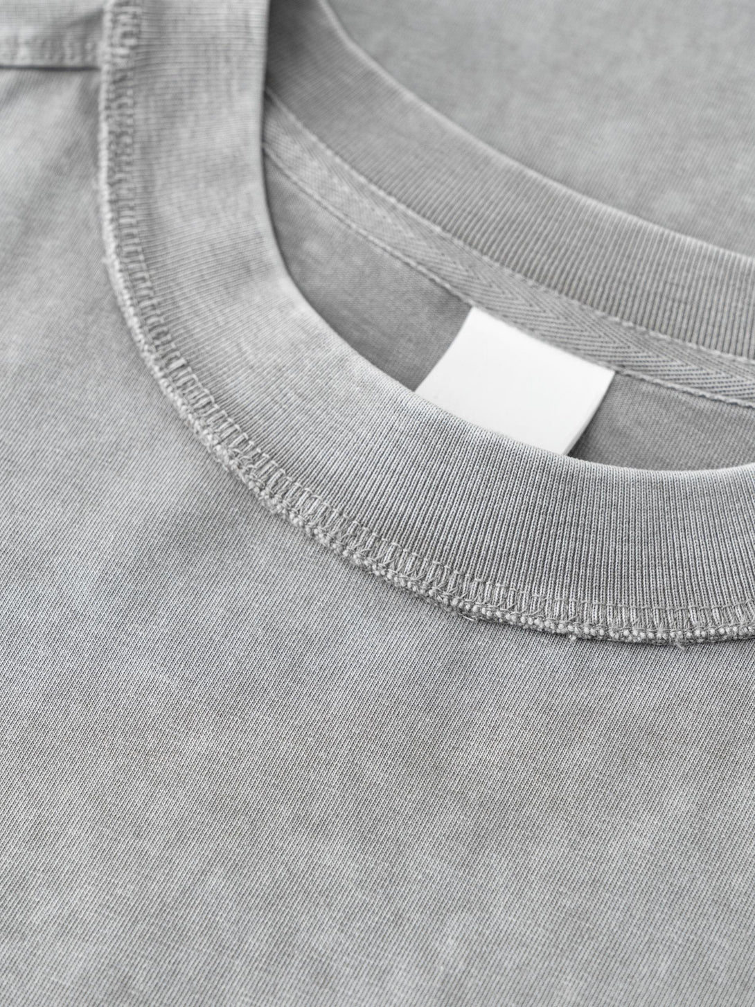 Reinforced collar construction detail on Light Gray oversized cotton tee for durable garment production.