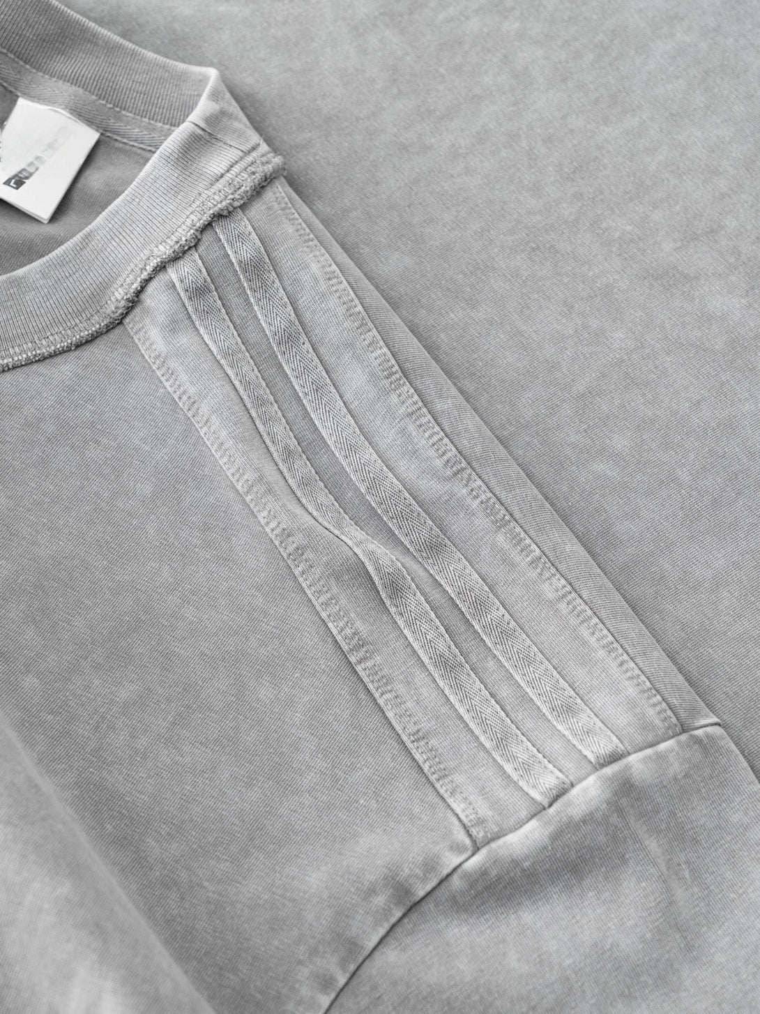 Shoulder seam reinforcement on Light Gray 100% cotton streetwear tee, manufacturing quality control detail.