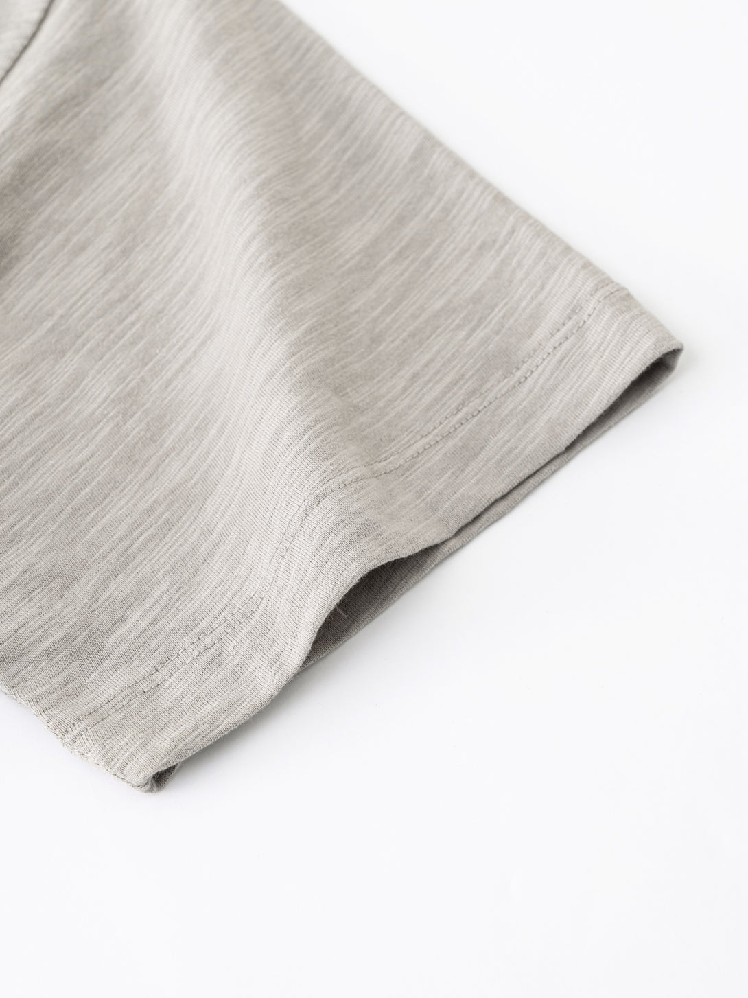 Sleeve cuff stitching and textured weave close-up on Light Gray breathable cotton tee.
