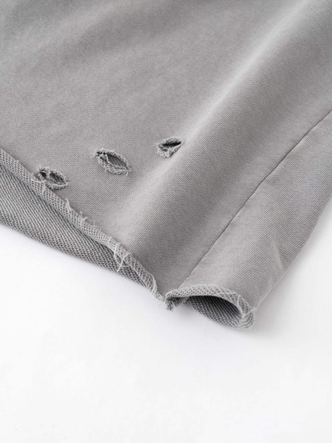 Raw-edge hem with pigment-drip effect - Light gray snow-wash finish detail for wholesale blanks
