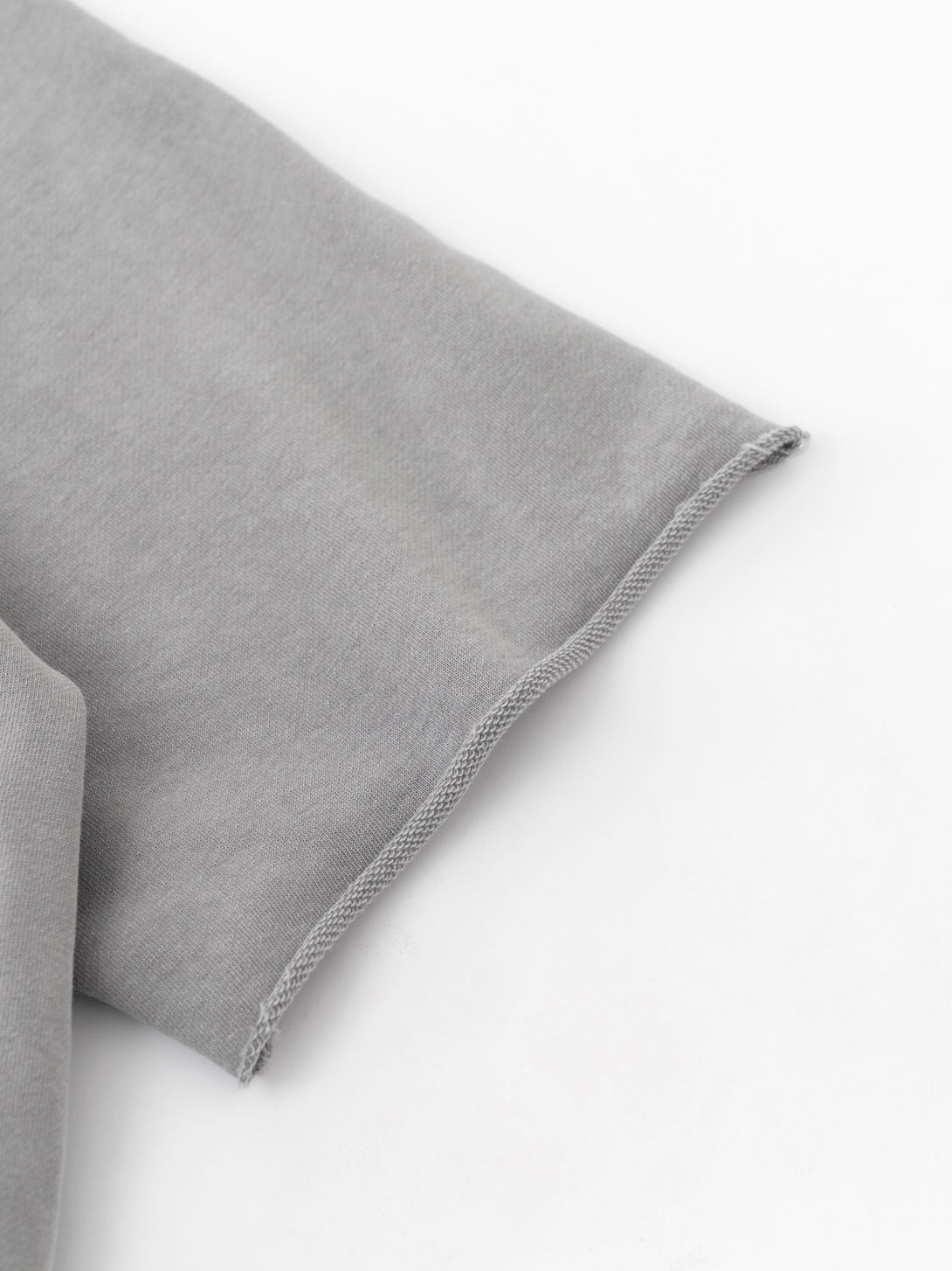 Light gray sleeve graffiti print close-up - Snow-wash texture on raw-edge cuff | Bulk blank QC sample
