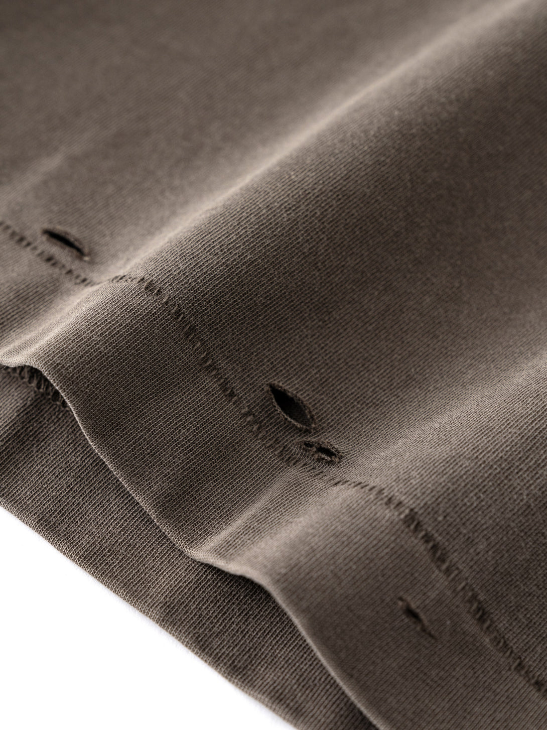 Raw-edge hem pigment-drip effect - Coffee distressed finish production detail