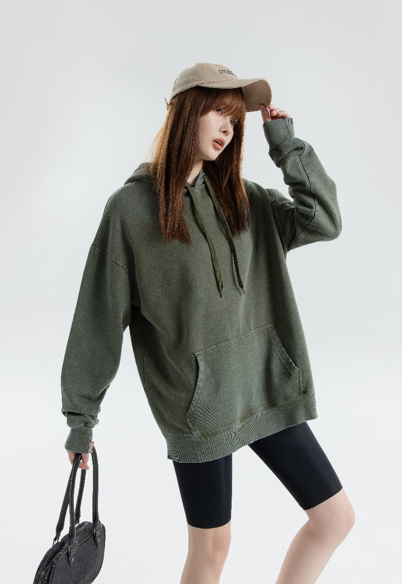 Vintage Wash Hoodie worn by a model with green oversized style, featuring a hood and front pocket.