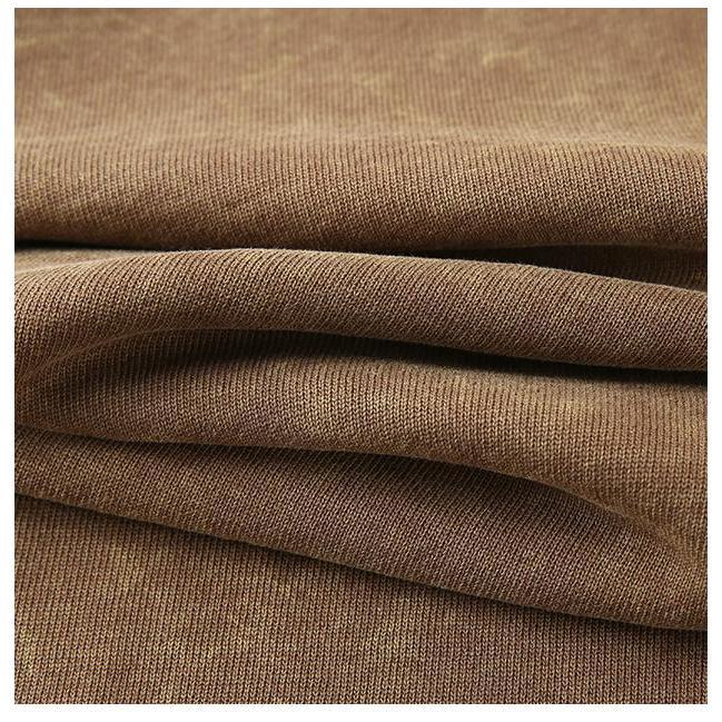 Close-up of soft, vintage wash hoodie fabric, showcasing the brown cotton texture, ideal for unisex pullovers.