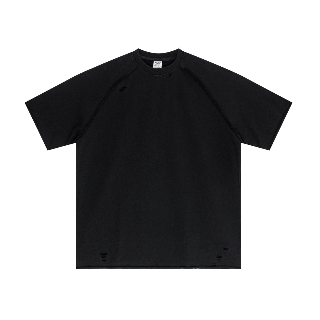 Black vintage streetwear tee showcasing artisan snow-wash effect and raw-edge hem, oversized front view. Wholesale apparel business essential.