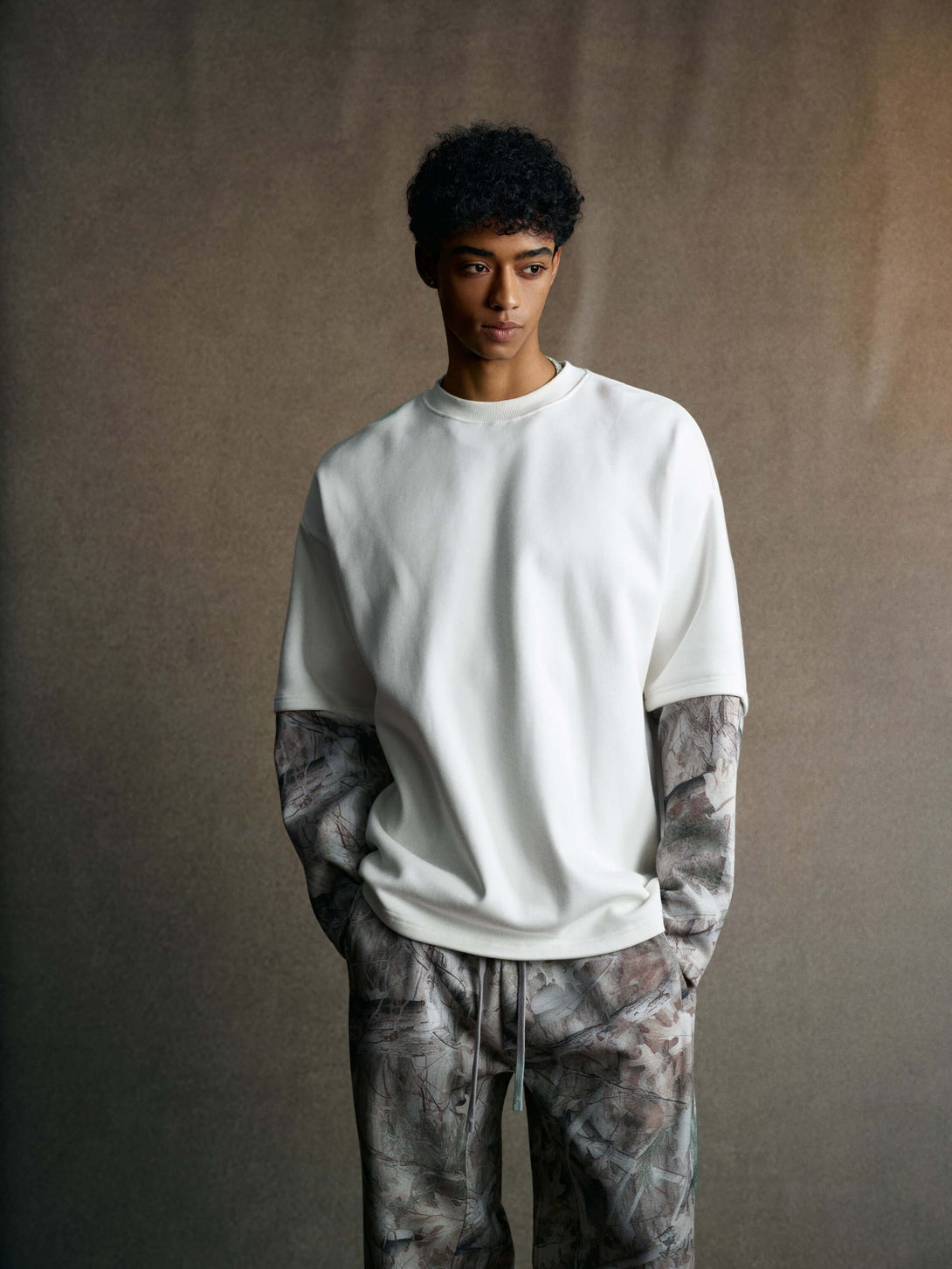 Men's 340g White Layered Camo Sweatshirt worn with patterned pants, showcasing stylish camo apparel.