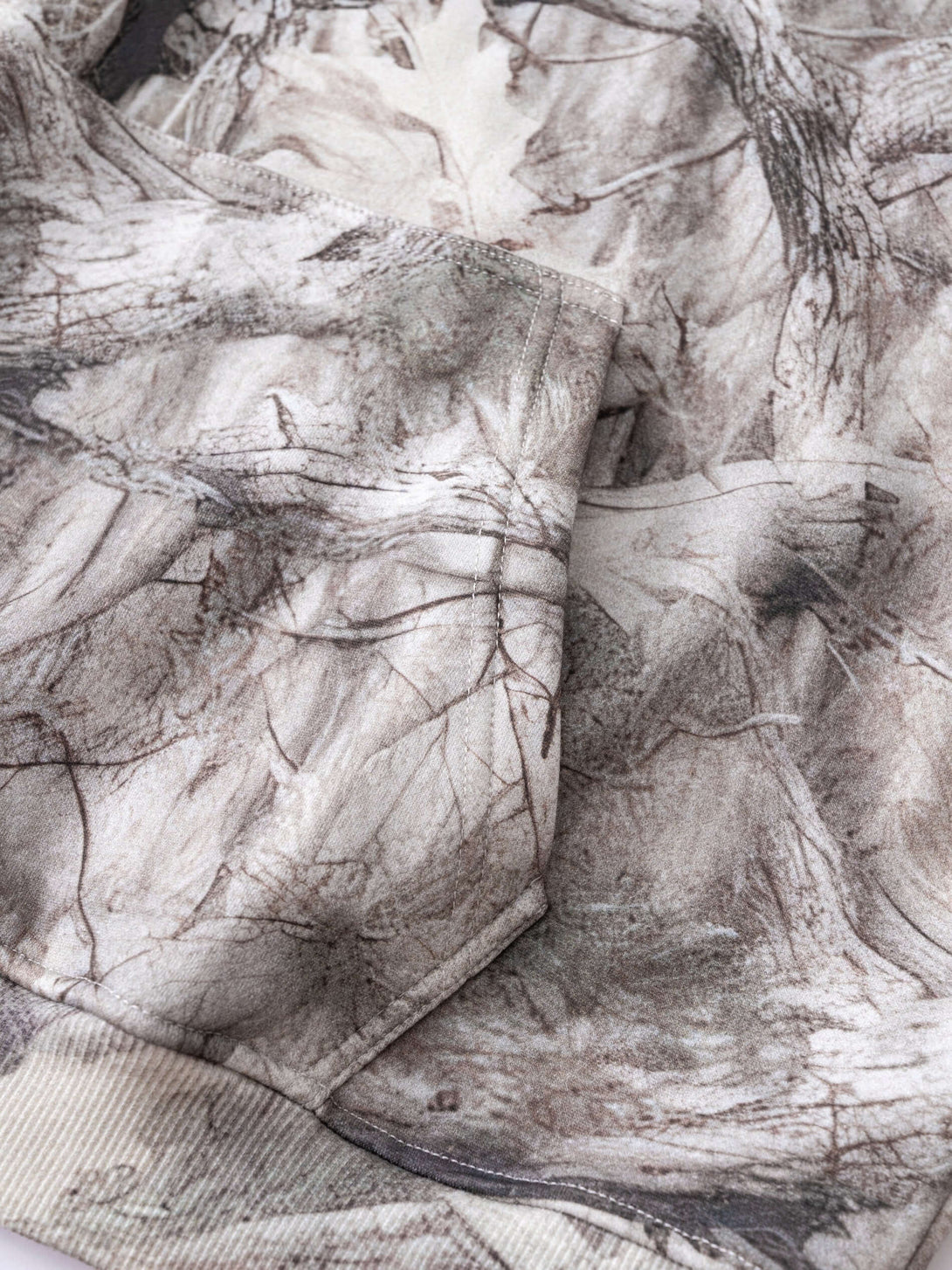 Men's Woodland Camo Hoodie fabric detail showcasing the durable heat transfer print and camouflaged design.