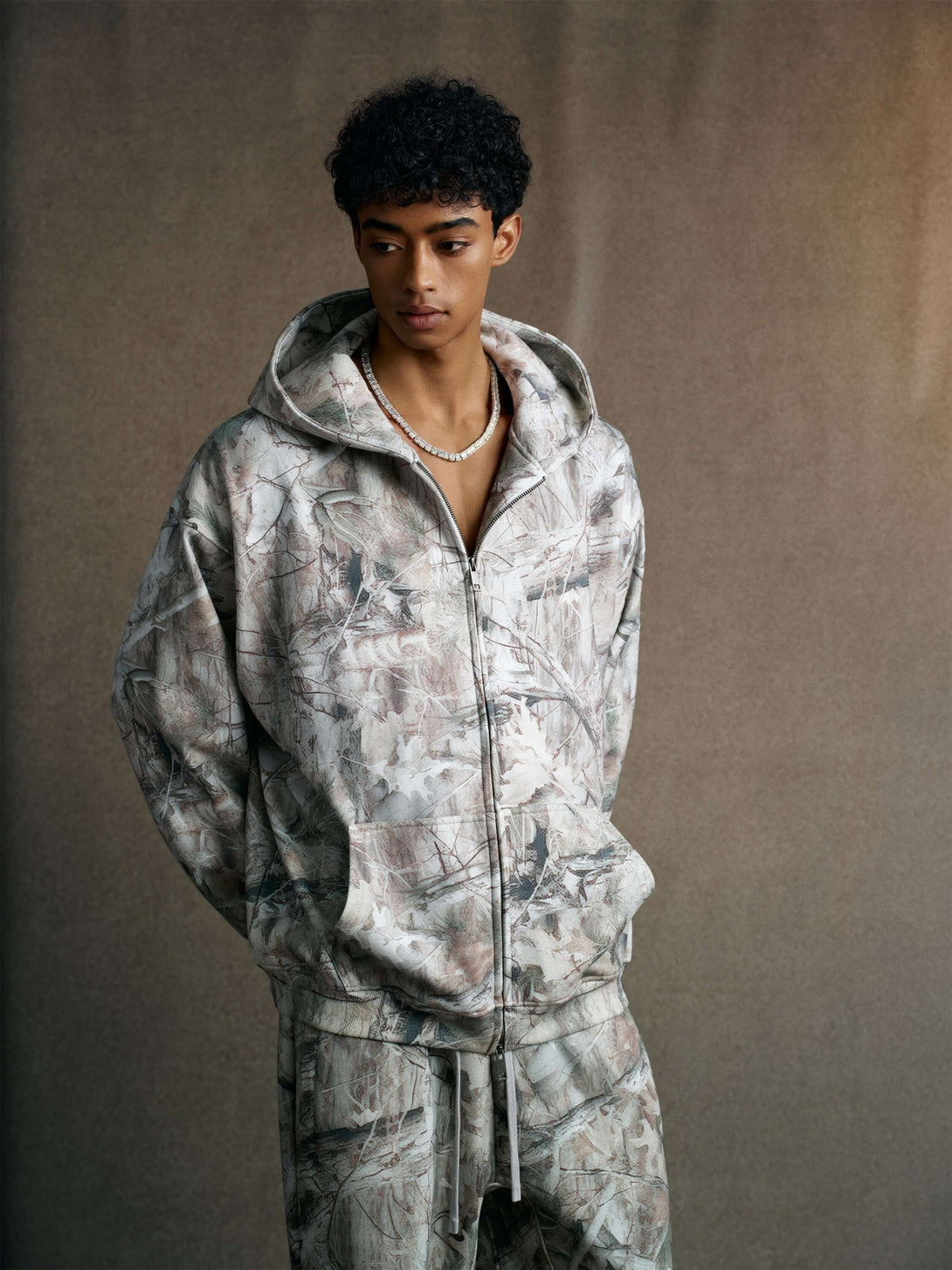 Men's 340g Woodland Camo Zip Up Hoodie worn by a model, showcasing stylish camouflage design and premium fabric.